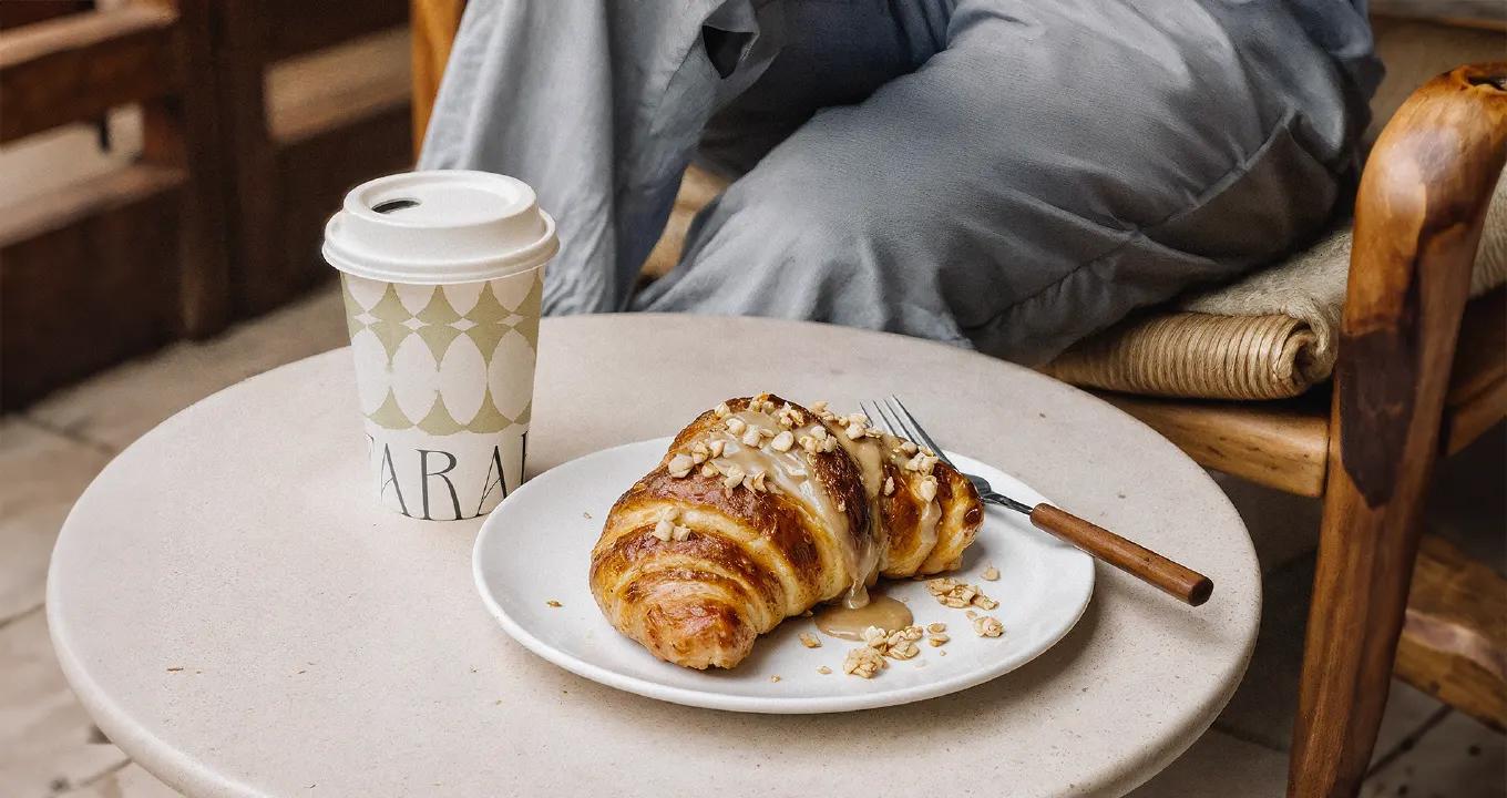 A fresh croissant and latte on a table